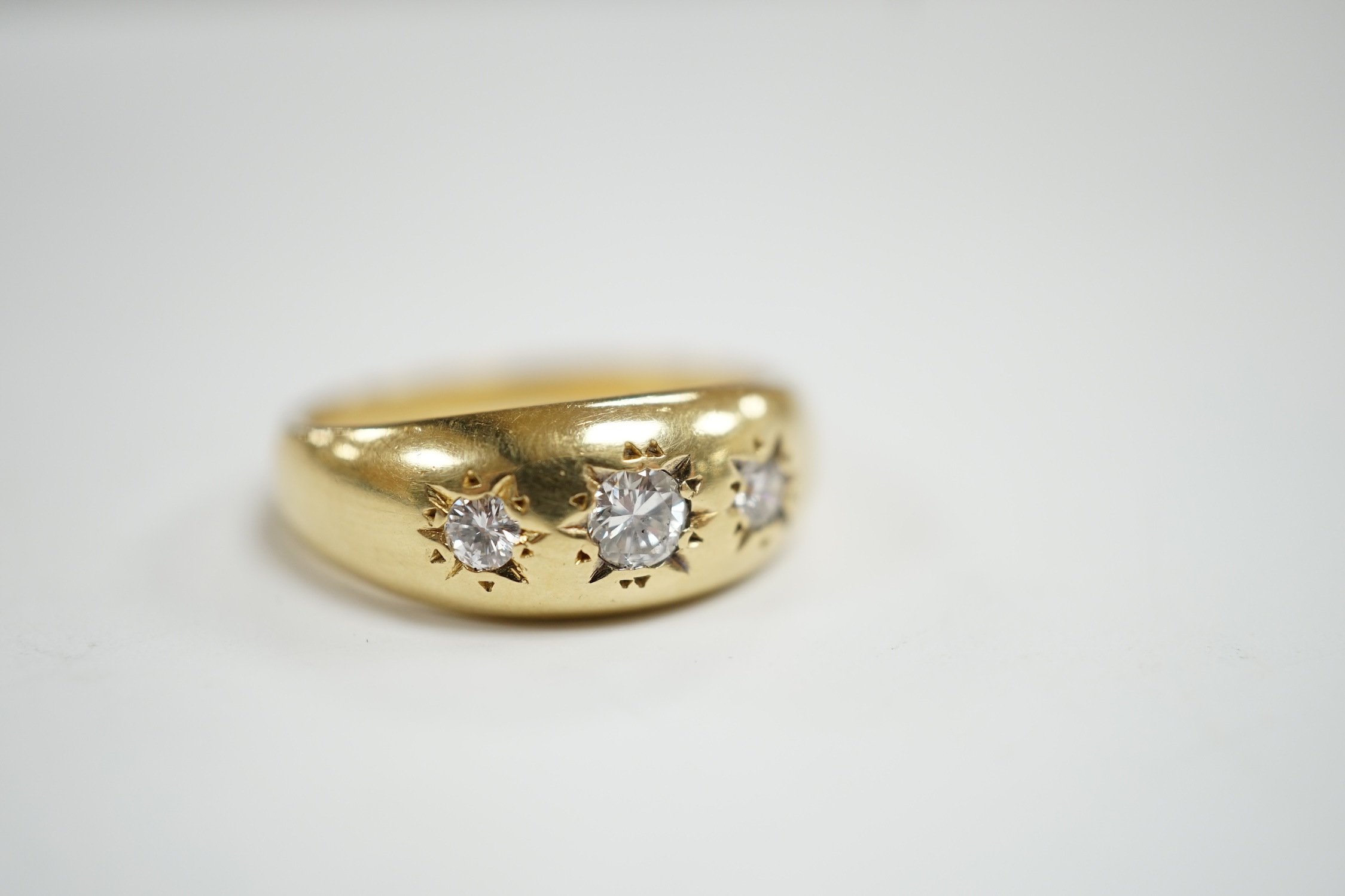 A modern 18ct gold and gypsy set three stone diamond ring, size S, gross weight 7.9 grams.